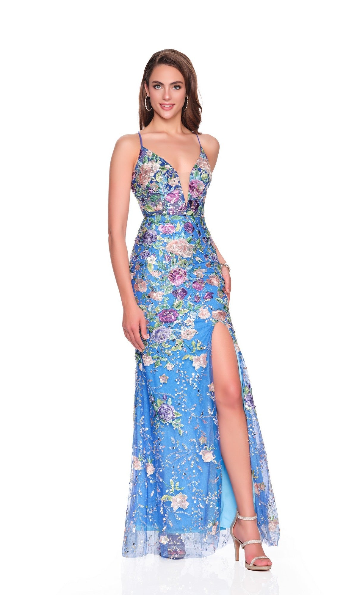 A woman poses against a white background wearing the Long Prom Dress: Dave and Johnny 12760, which features blue floral motifs, a deep V neckline, thin straps, a high slit, and a lace-up open back.